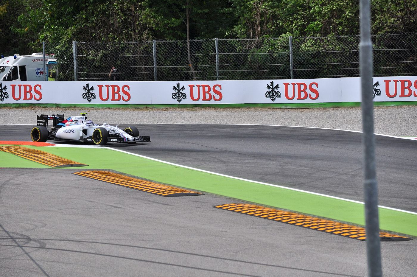 Valtteri Bottas driving the Williams FW37 with its front right wheel off the ground